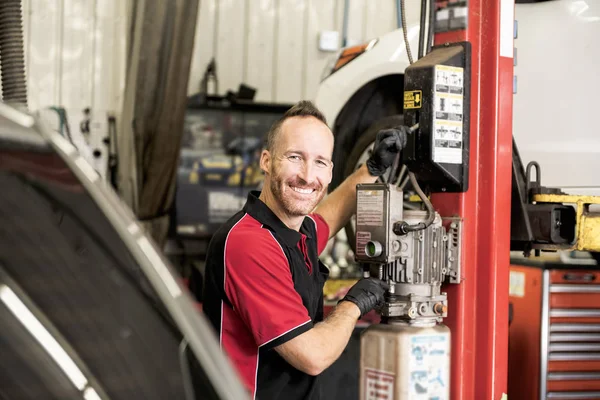 Gutaussehender Mechaniker mit Auto in der Autowerkstatt — Stockfoto