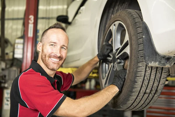 Gutaussehender Mechaniker mit Auto in der Autowerkstatt — Stockfoto