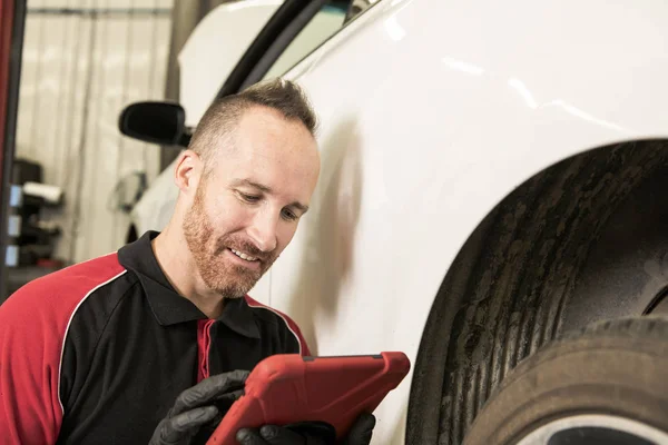 Gutaussehender Mechaniker mit Tablet in der Autowerkstatt — Stockfoto
