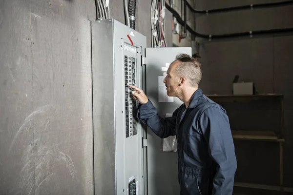 Técnico de hombre servicio en el trabajo en la habitación eléctrica —  Fotos de Stock