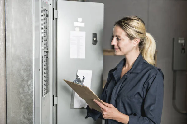 Vrouw technicus onderhoud aan het werk op elektrische kamer — Stockfoto