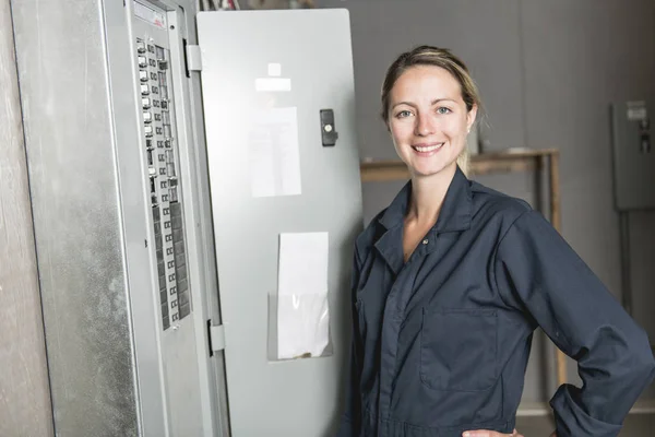 Vrouw technicus onderhoud aan het werk op elektrische kamer — Stockfoto