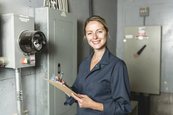 在电气室工作的妇女技术员服务 — 图库照片