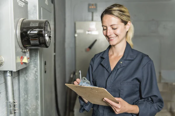 Vrouw technicus onderhoud aan het werk op elektrische kamer — Stockfoto