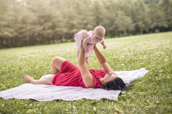 Happy mother with Baby girl lay on a blanket — Stock Photo, Image