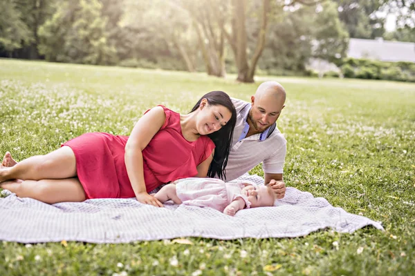 快乐的家庭与女婴躺在毯子上 — 图库照片