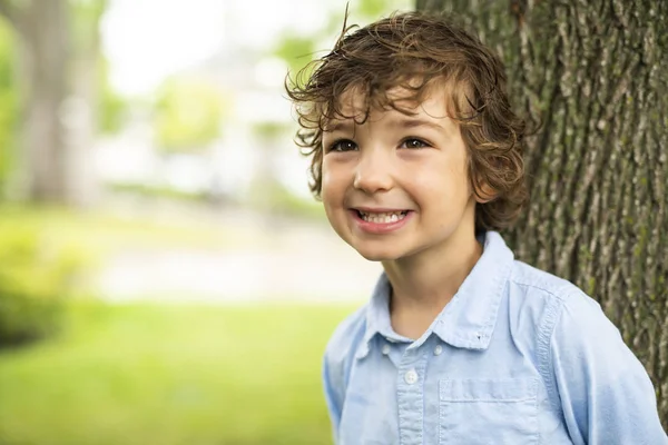 Mignon caucasien garçon heureux près d 'un arbre — Photo