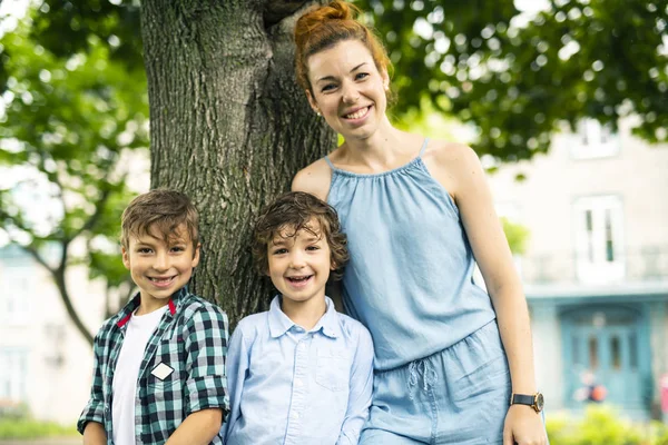 幸福的母亲和两个儿子在公园的肖像 — 图库照片
