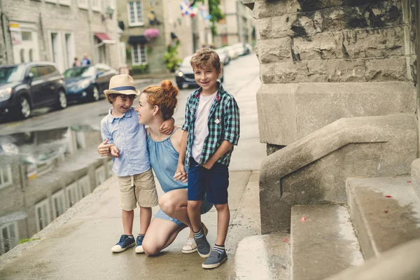 Moeder met haar twee zoon buiten in een urban street — Stockfoto
