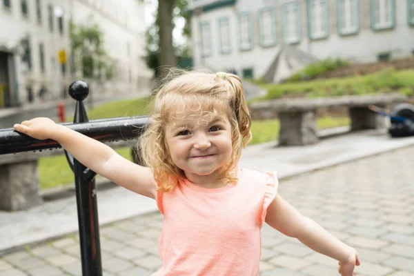 Dziewczynka w miejskim otoczeniu uśmiecha się do kamery — Zdjęcie stockowe