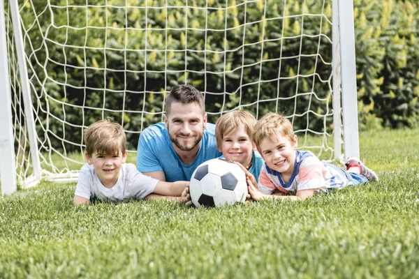 Man met kind voetballen buiten op het veld — Stockfoto