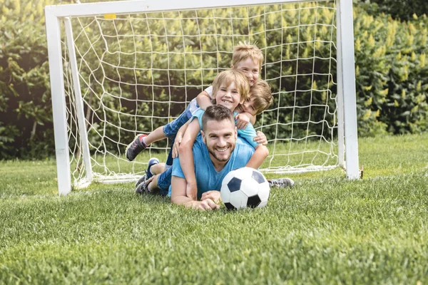 Άντρας με παιδί παίζει ποδόσφαιρο έξω στο γήπεδο — Φωτογραφία Αρχείου