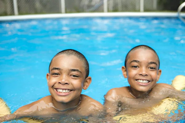 Retrato del hermano gemelo pasándolo bien en la piscina —  Fotos de Stock