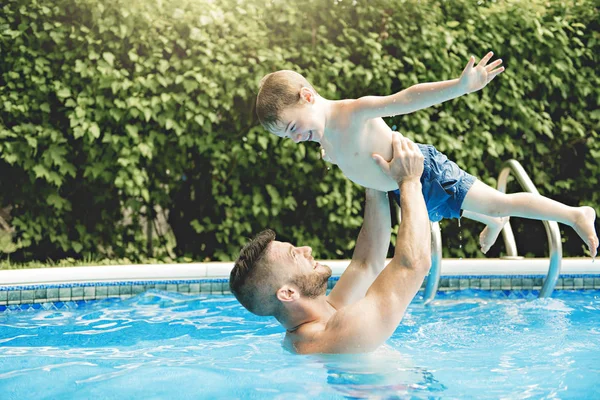 可爱的小男孩有乐趣与父母在游泳池 — 图库照片