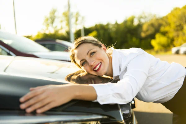 ガレージで車を抱いて車販売女性 — ストック写真
