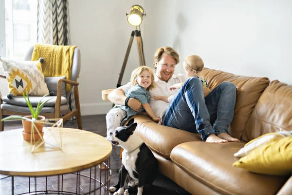 Joven padre con hija e hijo en el sofá en casa — Foto de Stock