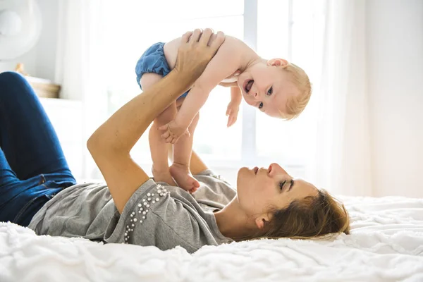 Mother and baby girl on bed — Stock Photo, Image