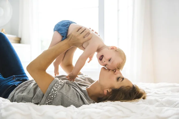 Mother and baby girl on bed — Stock Photo, Image