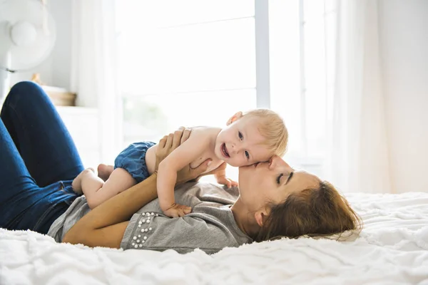 Mother and baby girl on bed — Stock Photo, Image
