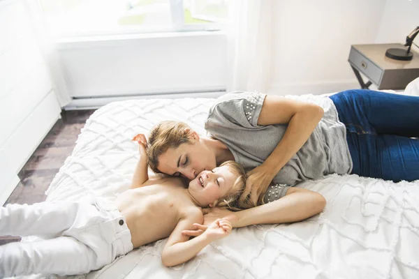 Young mother with her little son relaxing and playing in the bed at the weekend together — Stock Photo, Image