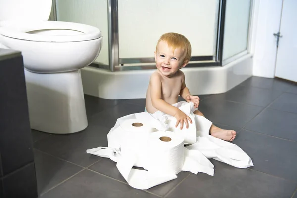 Kleinkind zerreißt Toilettenpapier im Badezimmer — Stockfoto