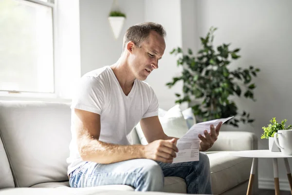 Bad news. Depressed mature man holding paper — Stock Photo, Image