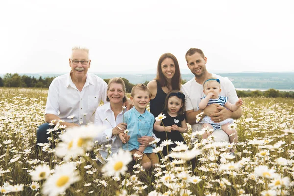 Rodina s prarodiče trávit čas s malým dítětem během západu slunce. — Stock fotografie