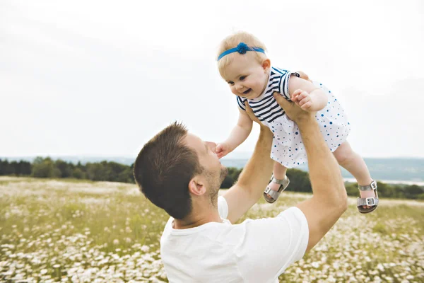 Little baby girl and his father enjoying outdoors in field of daisy flowers — Stock Photo, Image