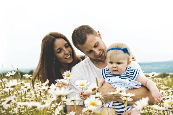 Littlegirl and his father and mother enjoying outdoors in field of daisy flowers — Stock Photo, Image