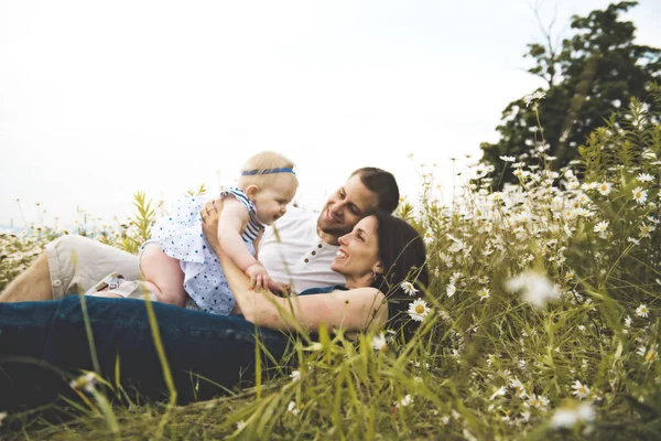 Littlegirl and his father and mother enjoying outdoors in field of daisy flowers — Stock Photo, Image