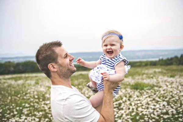 Little baby girl and his father enjoying outdoors in field of daisy flowers — Stock Photo, Image
