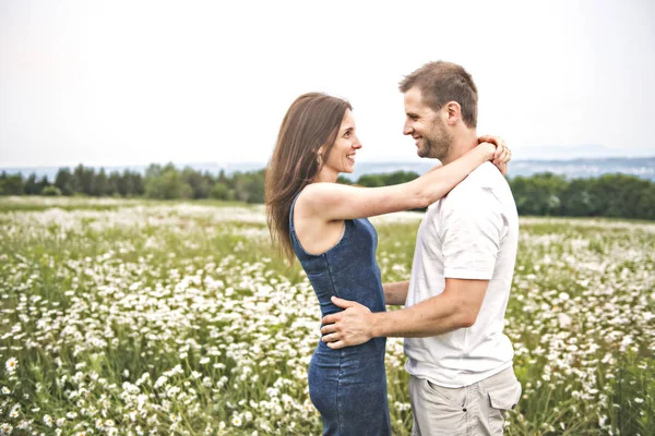 Couple in love outdoor at the sunset daisy — Stock Photo, Image