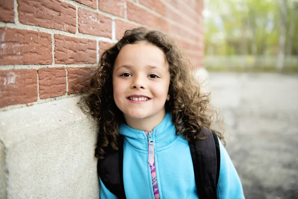 Portrait of cute girl with backpack outside of school — Stock Photo, Image