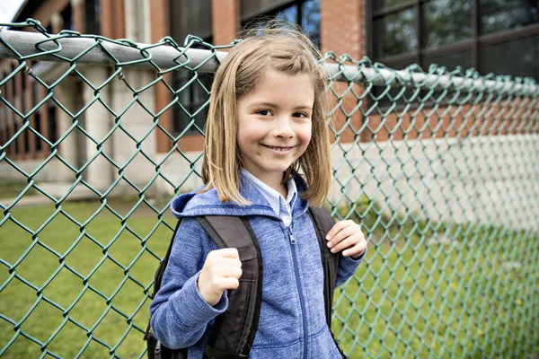 Portrait of cute girl with backpack outside of school — Stock Photo, Image