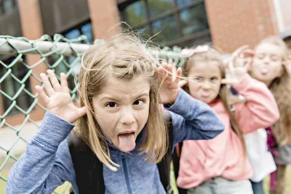 En gruppe elever udenfor i skolen, der står sammen - Stock-foto