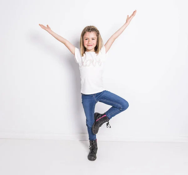 Portret van een schattig 7 jaar oud meisje geïsoleerd op witte achtergrond doet yoga — Stockfoto