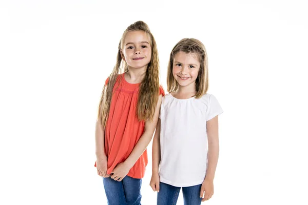 Két aranyos meg 7 év régi lány elkülönített felett fehér háttér portréja — Stock Fotó