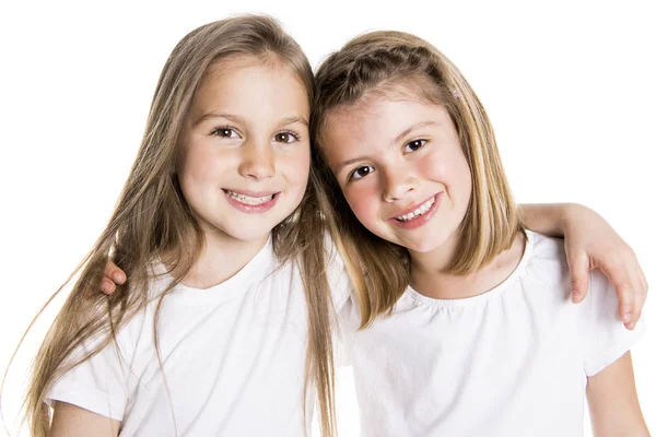 Két aranyos meg 7 év régi lány elkülönített felett fehér háttér portréja — Stock Fotó