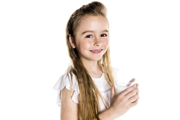 Retrato de una linda niña de 7 años aislada sobre fondo blanco con vaso de leche — Foto de Stock