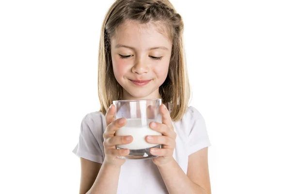 Portret van een schattig 7 jaar oud meisje geïsoleerd op witte achtergrond met melkglas — Stockfoto