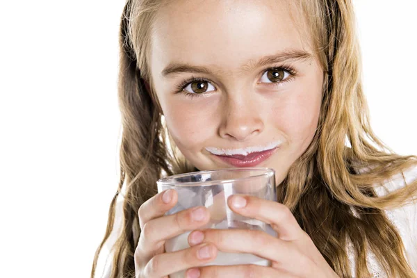 Portréja egy aranyos 7 éves lány elkülönített felett fehér háttér pohár tej — Stock Fotó