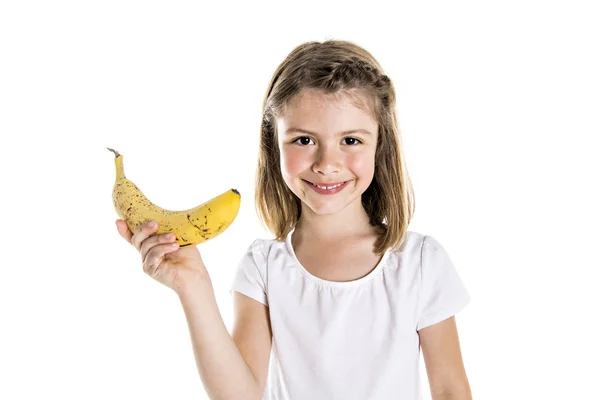 Portré egy aranyos 7 év régi lány elkülönített felett fehér háttér, banán — Stock Fotó