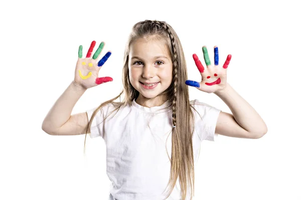 Chica sonriente con las palmas pintadas por una pintura. Aislado sobre fondo blanco — Foto de Stock