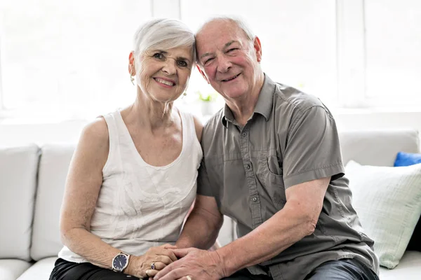 ソファに一緒に座って愛情のこもった魅力的な老夫婦 — ストック写真