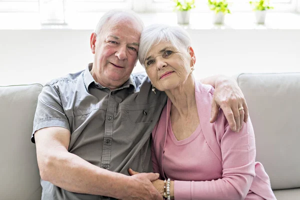 Affectionate attractive elderly couple sitting together on a couch — Stock Photo, Image