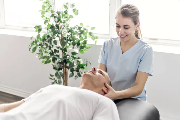 Paciente na fisioterapia fazendo exercícios físicos com seu terapeuta — Fotografia de Stock