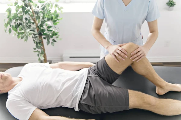 Paciente en fisioterapia haciendo ejercicios físicos con su terapeuta — Foto de Stock
