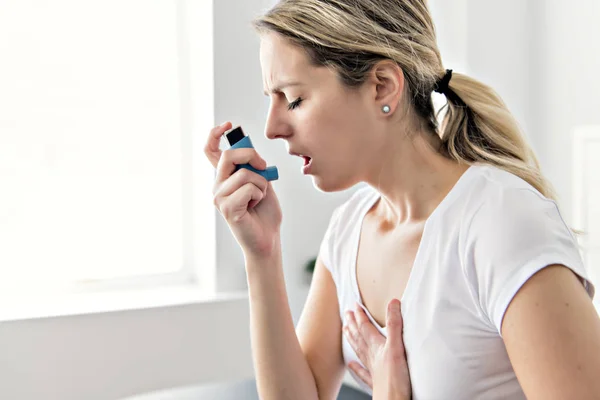 Una asmática usando su inhalador debido a dificultades para respirar — Foto de Stock