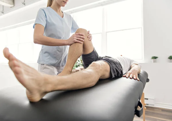 Patient at the physiotherapy doing physical exercises with his therapist — Stock Photo, Image