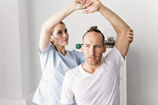 Patient in der Physiotherapie macht körperliche Übungen mit seinem Therapeuten — Stockfoto